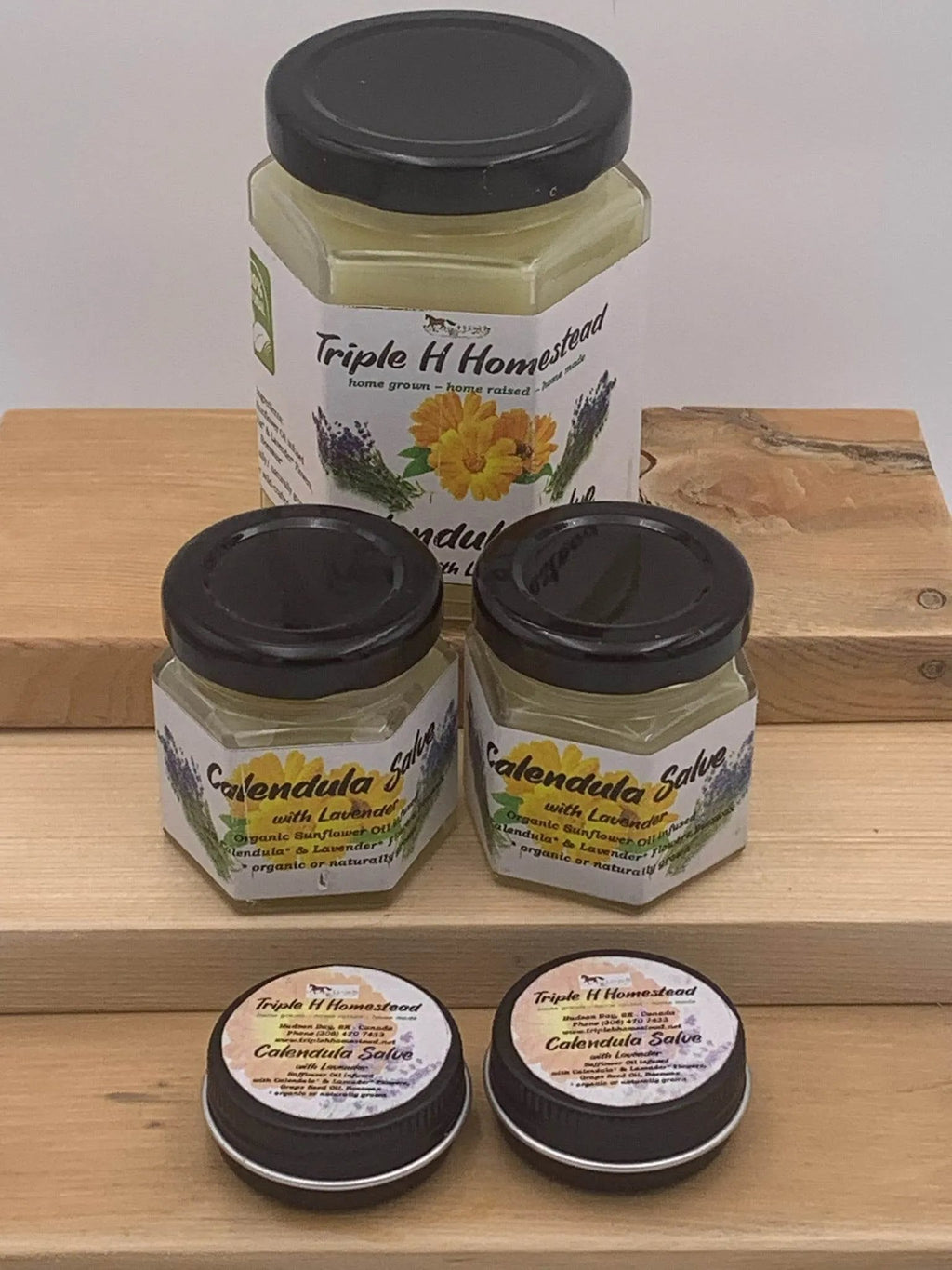 Jars of Triple H Homestead calendula salve on a wooden surface