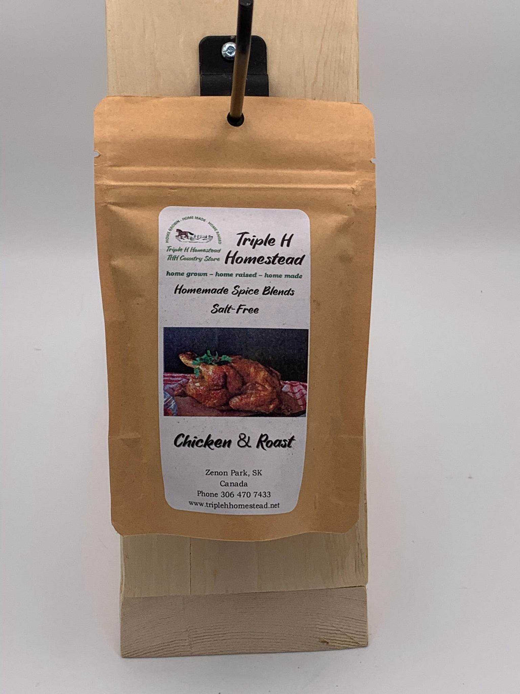 Packaged spice blend labeled 'Triple H Homestead' on a wooden board with a white background