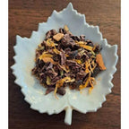 Chocolate Chai on a white leaf-shaped dish on a wooden surface