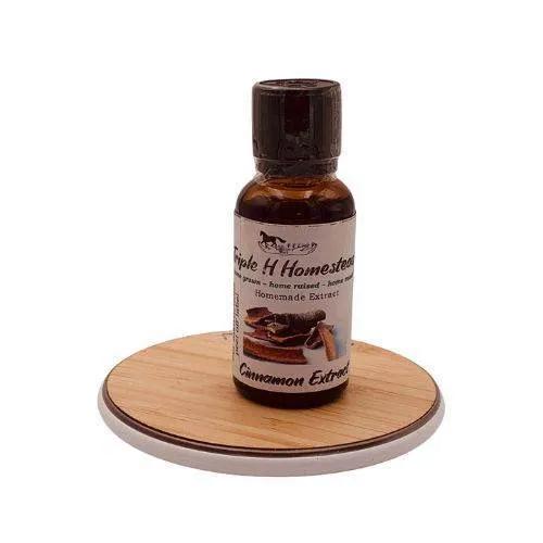 Bottle of cinnamon extract on a wooden coaster with a white background