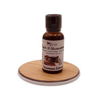 Bottle of cinnamon extract on a wooden coaster with a white background