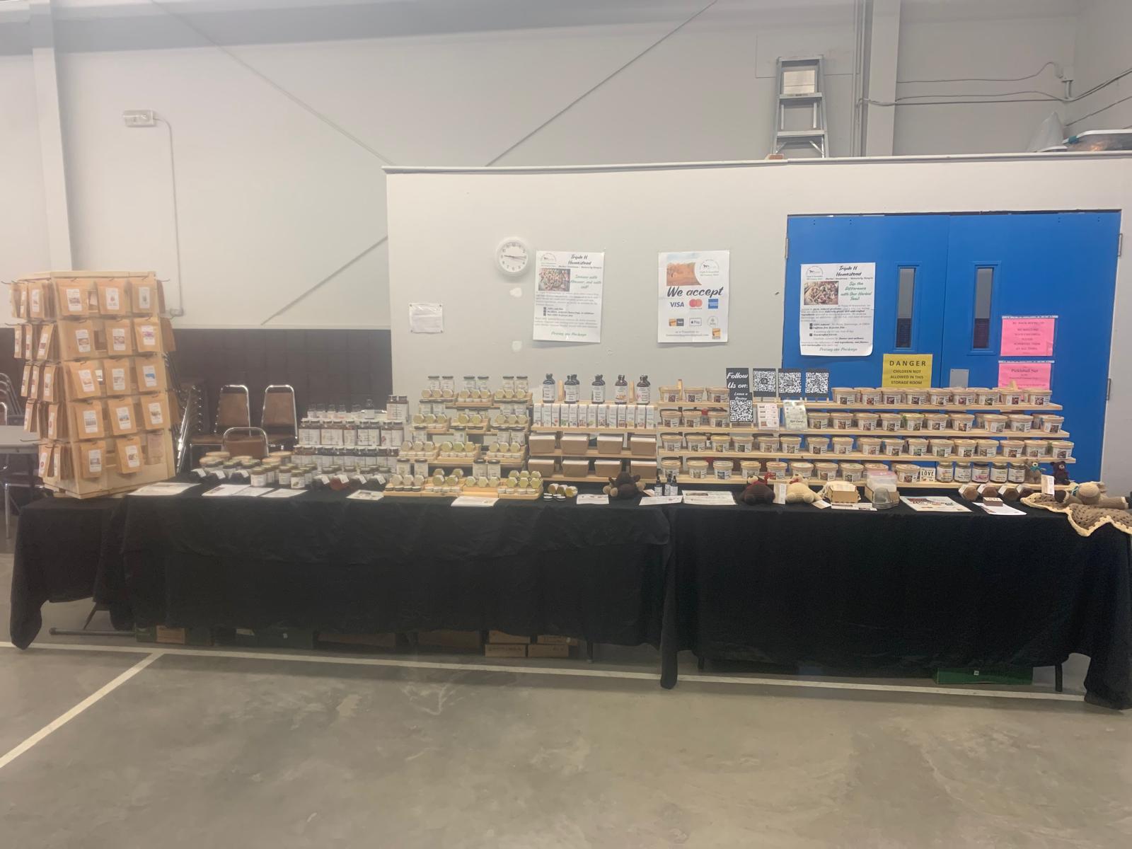 Display of products on a table with a black cover in an indoor setting.