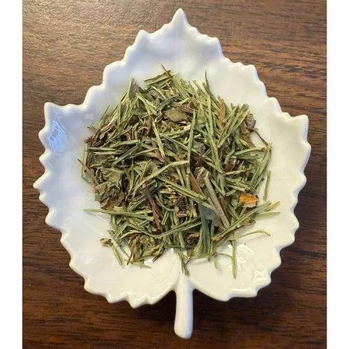 Diuretic Tea  herbs in a white ceramic dish on a wooden surface