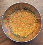 Metal bowl filled with French Fry Seasoning spice mix on a wooden surface