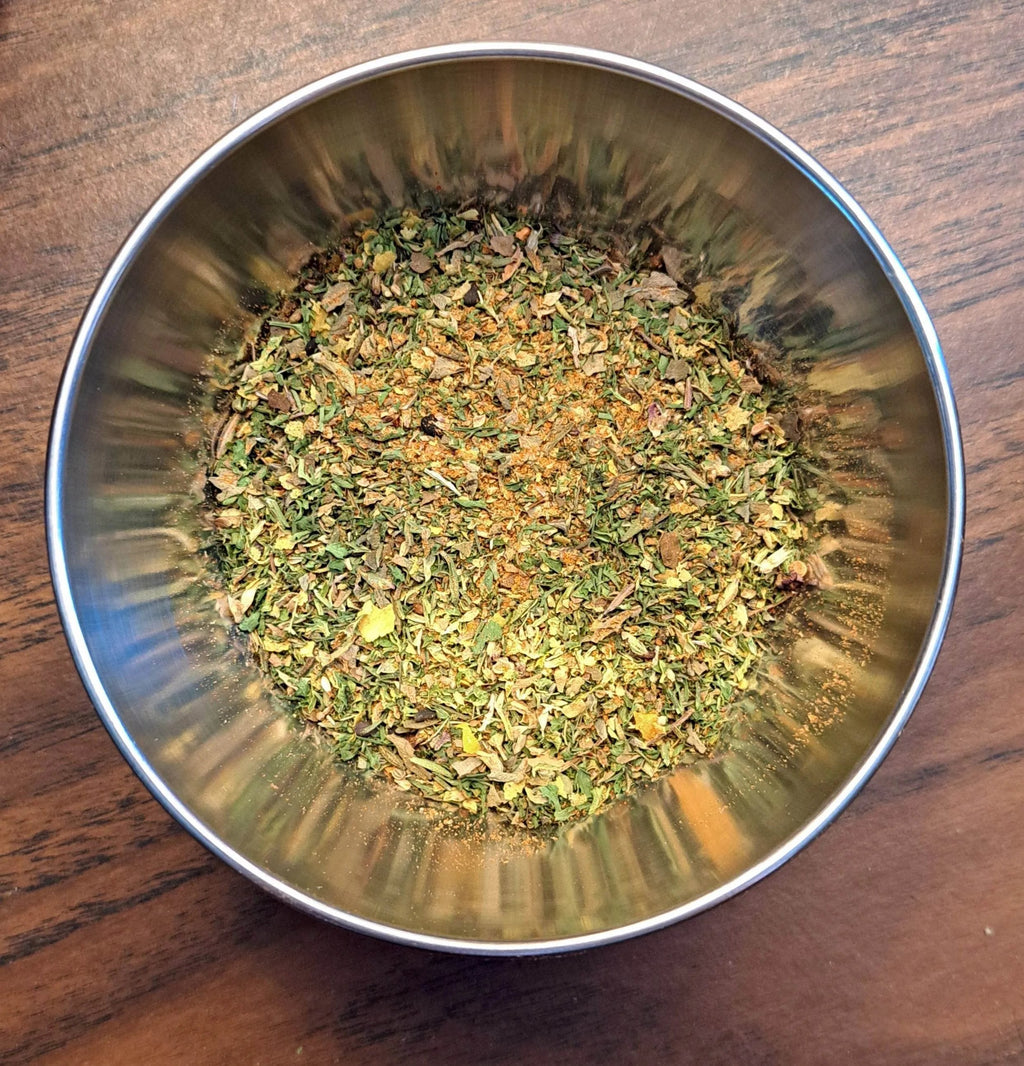 Metal bowl filled with Garden Medley Dip spice mix on a wooden surface