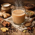 Glass mug of Herbal chai tea with spices and ingredients on a wooden surface