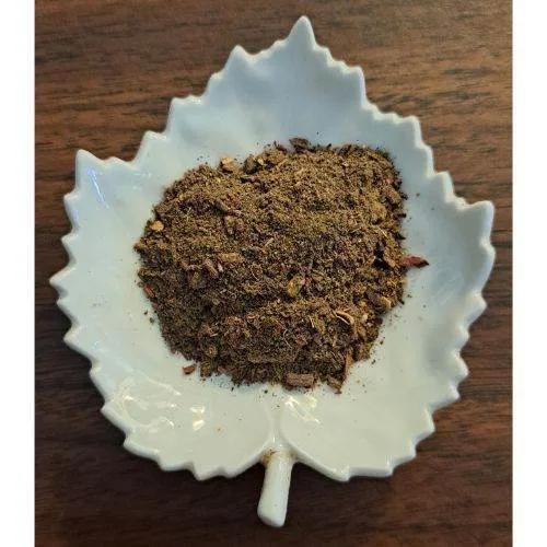 Hibiscus Mint Latte powder on a white ceramic leaf-shaped dish on a wooden surface