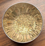 Metallic bowl with Italian Seasoning on a wooden surface