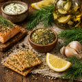 Salmon dish with a bowl of the Lemony Dill Mic in a bowl, and herbs, lemon, and crackers on a wooden surface