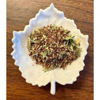 Magnesium Boost Herbal mix in a white decorative bowl on a wooden surface