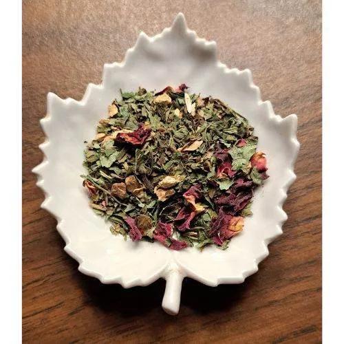 Mom's Morning Wellness herbs in a white ceramic dish on a wooden surface