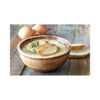 Bowl of soup with croutons on a wooden table
