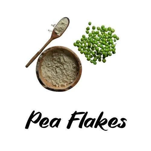 Pea flakes with a bowl of ground powder and a spoon on a white background