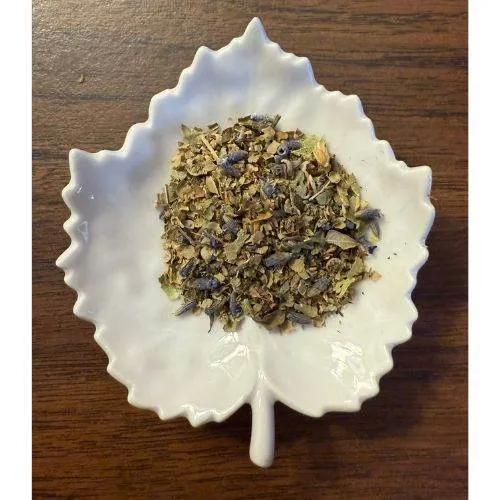 Peaceful Evening Herbal mix on a white ceramic leaf-shaped dish on a wooden surface