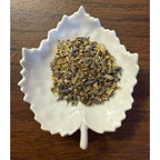 Peaceful Evening Herbal mix on a white ceramic leaf-shaped dish on a wooden surface