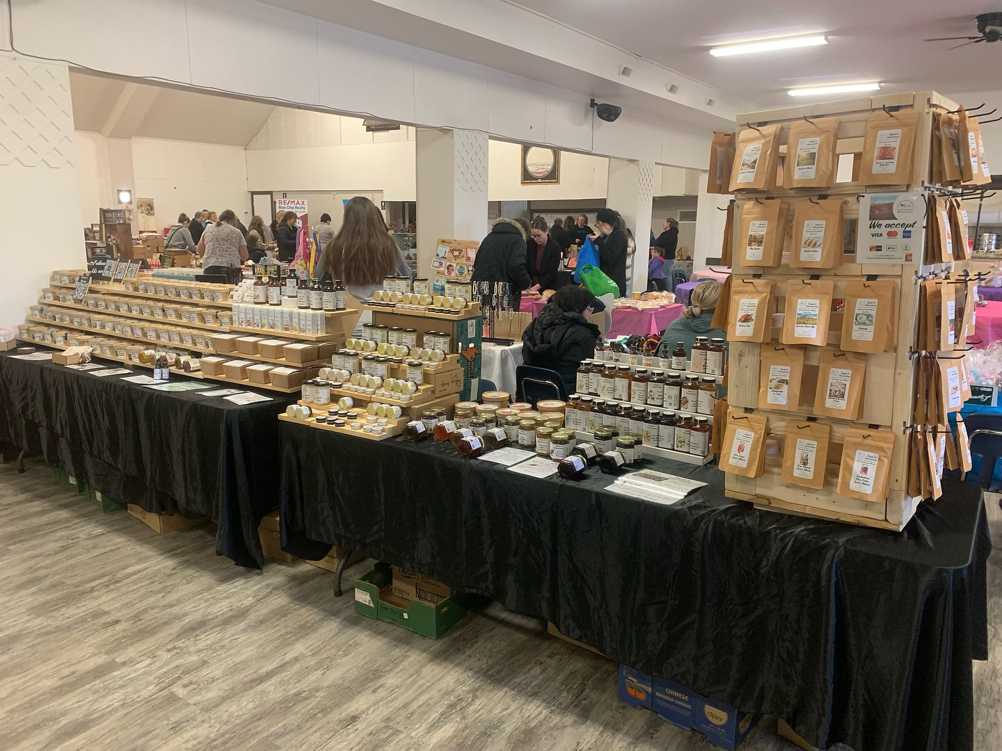 Product display setup with tables and shelves in a room with people in the background