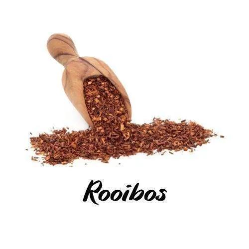 Wooden scoop filled with rooibos tea leaves on a white background