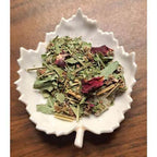 Saskatchewan Bliss Herbal tea mix on a decorative white plate with a wooden background