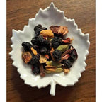 Saskatoon Chai mix in a white leaf-shaped bowl on a wooden surface