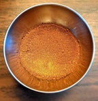 Metal bowl filled with Saskatoon Chocolate Spice on a wooden surface
