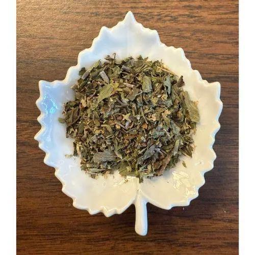 Shakespeare's Winter's Tale Tea in a white ceramic leaf-shaped bowl on a wooden surface