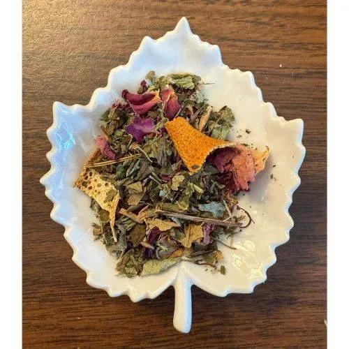 Soon to be Mom Herbal tea mix in a white leaf-shaped bowl on a wooden surface