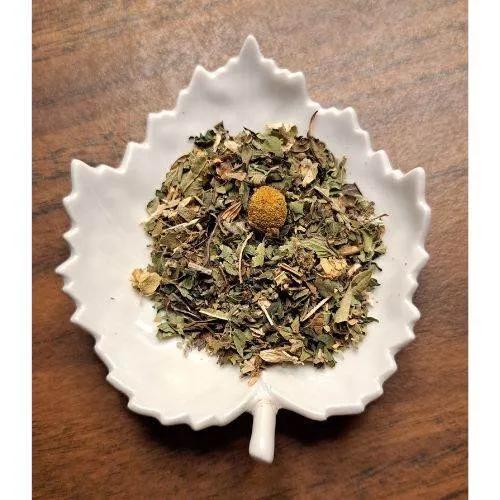 Stress Relief Herbal tea leaves in a white leaf-shaped bowl on a wooden surface