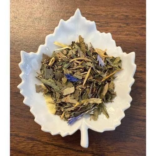 Study Buddy leaves in a white leaf-shaped bowl on a wooden surface