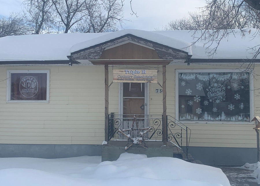 Building exterior with snow on the ground and a sign on the door.