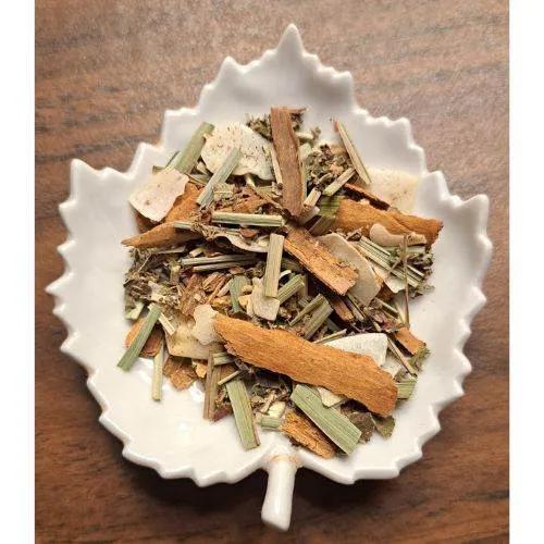 Tropical Tranquility Herbal mix in a white leaf-shaped bowl on a wooden surface