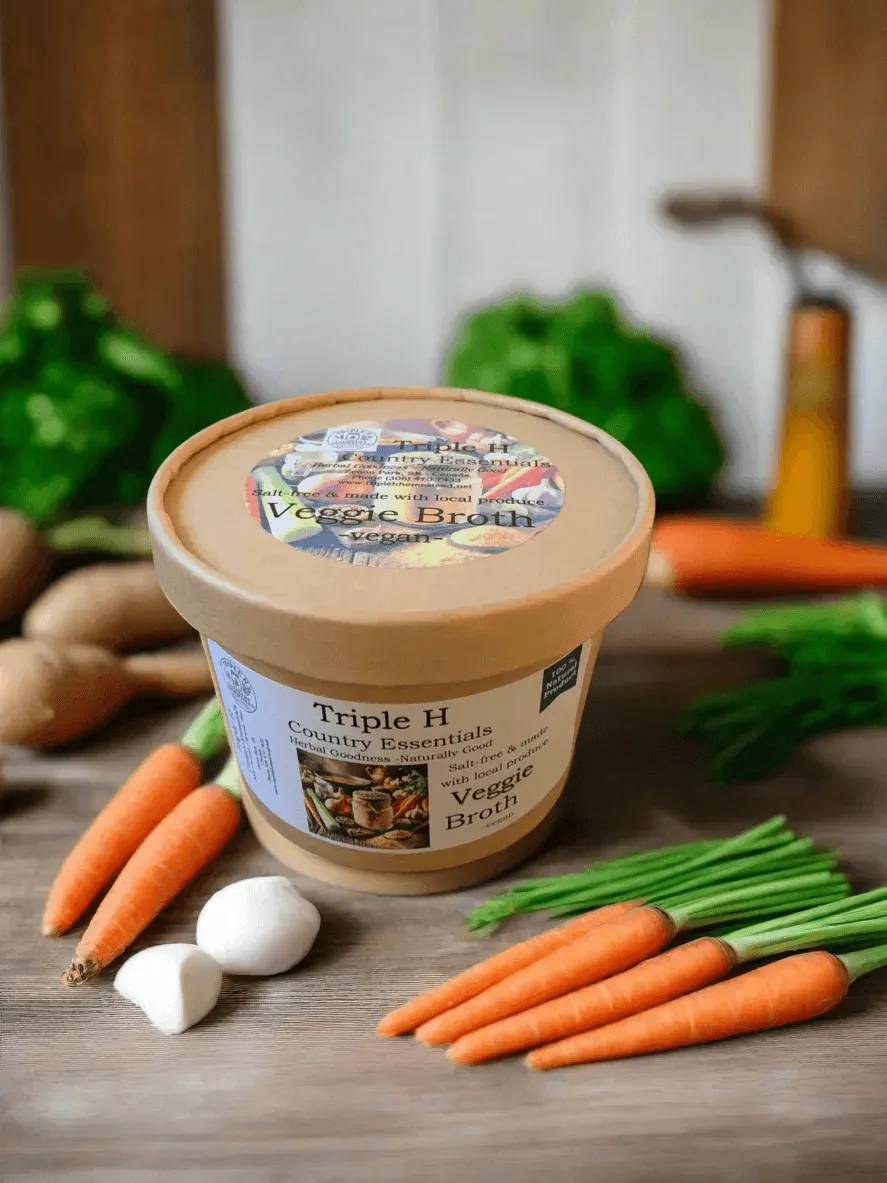 Triple H Veggie Broth container with vegetables on a wooden surface