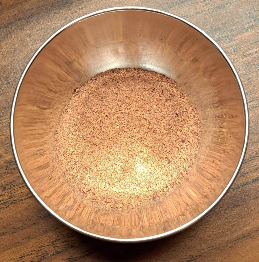 Metal bowl filled with Whimsical Brownie Friend spice mix on a wooden surface