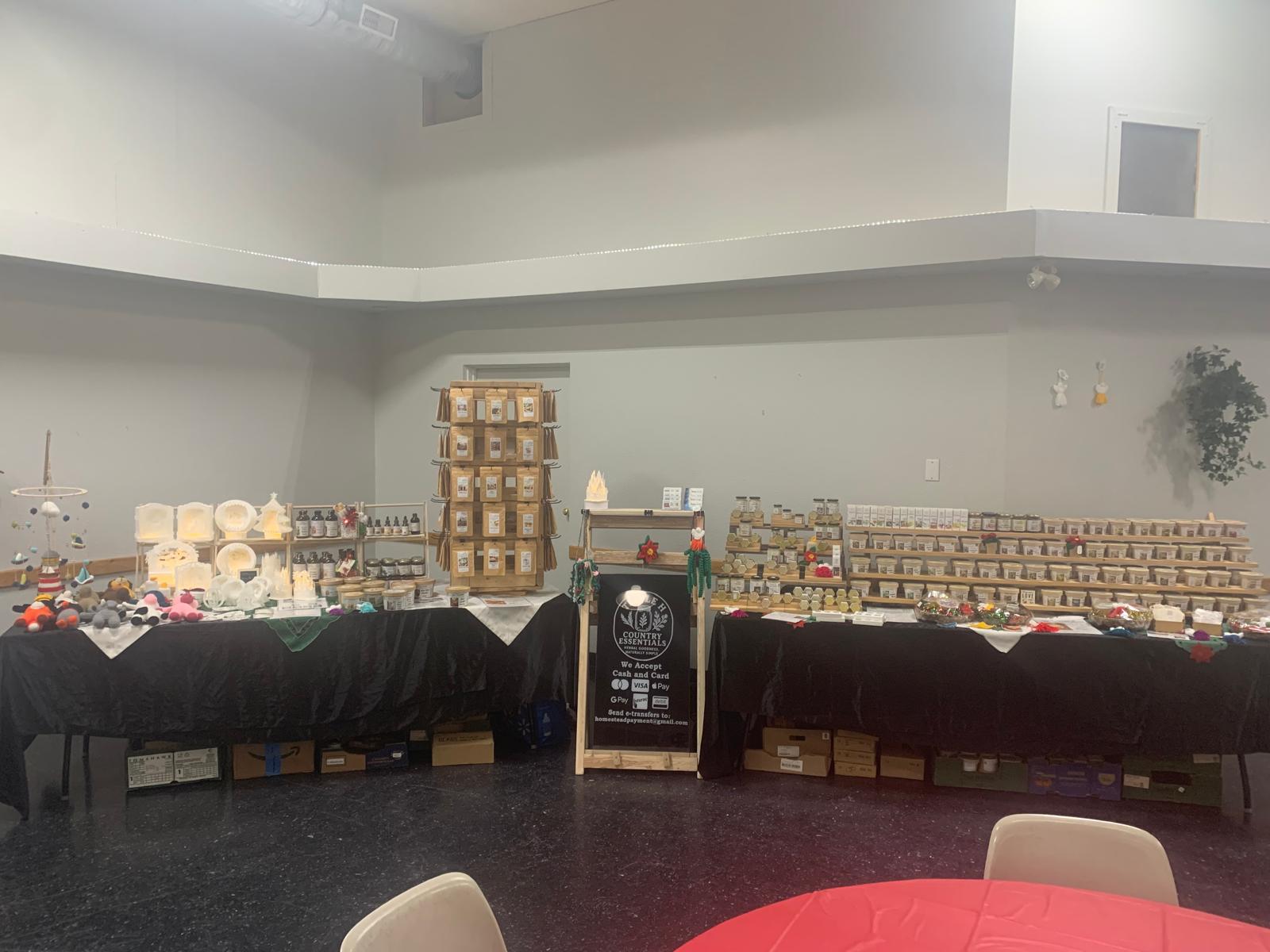 Large room with tables and chairs, shelves with products, and a chalkboard sign.