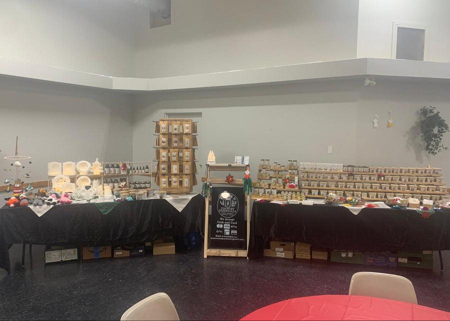 Large room with tables and chairs, shelves with products, and a chalkboard sign.