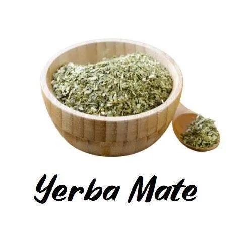 Wooden bowl and spoon filled with yerba mate on a white background