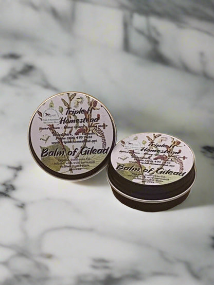 Triple H Homestead natural balm of gilead salve tins with botanical label on marble surface